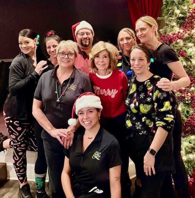 A group of people posing for the camera in Christmas attire.
