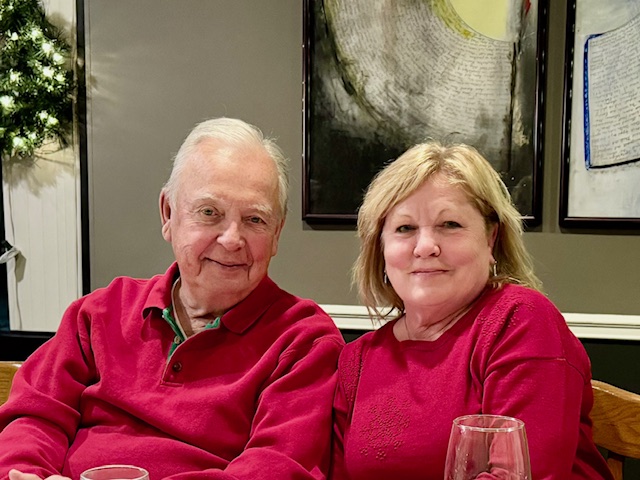 A pair of people posing for the camera in red attire.